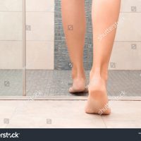 stock-photo-young-woman-getting-into-shower-cubicle-focus-on-legs-1212703126
